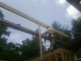 Carpenter setting a ridge beam over a new addition frame — Ice Dam Removal by Roofing Brothers in Milano