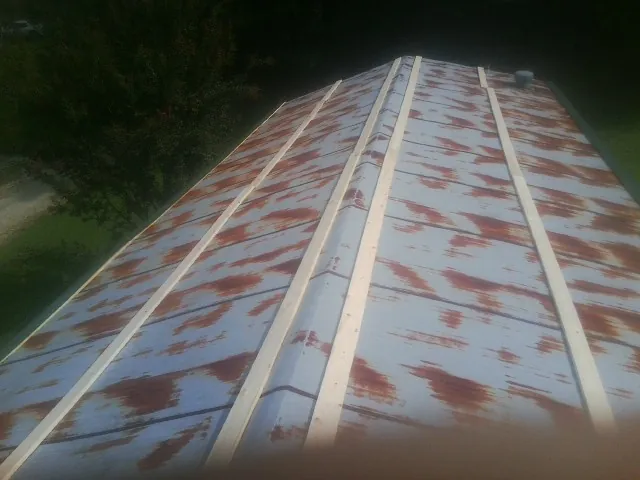 Rusted metal roof panels with new wood purlins before replacement — Storm Damage Roof Repair in Milano by Roofing Brothers
