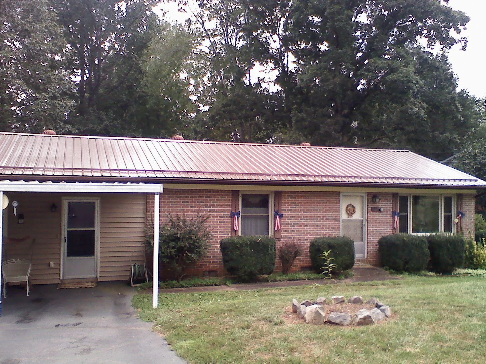 Bronze metal roof and carport on a brick ranch home — Roof Repair work by our crew in Milano